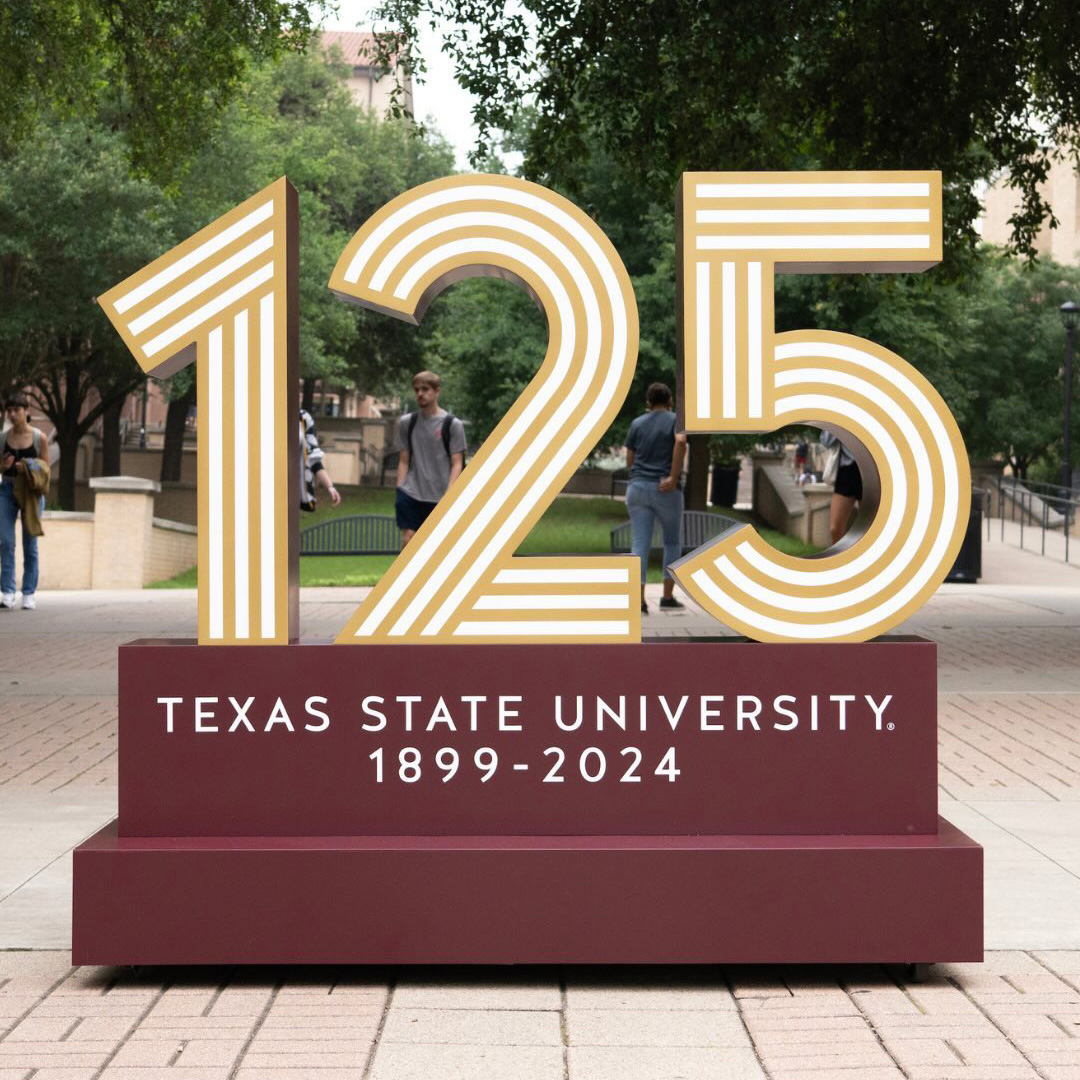 Giant sign with 125 Texas State University 1899-2024 in maroon and gold