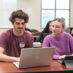 Male and female students looking at laptop computer