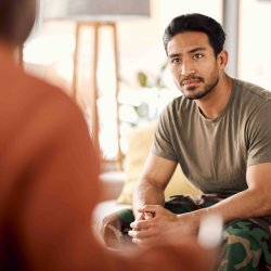 man in army fatigues speaking to therapist