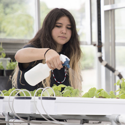 female student watering plants