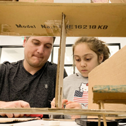 Man and young girl working together on computing project