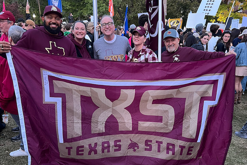 Five Bobcats holding the Texas State OMG flag at National College Game Day