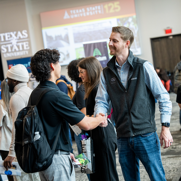 Student and employer shaking hands at a Texas State career fair