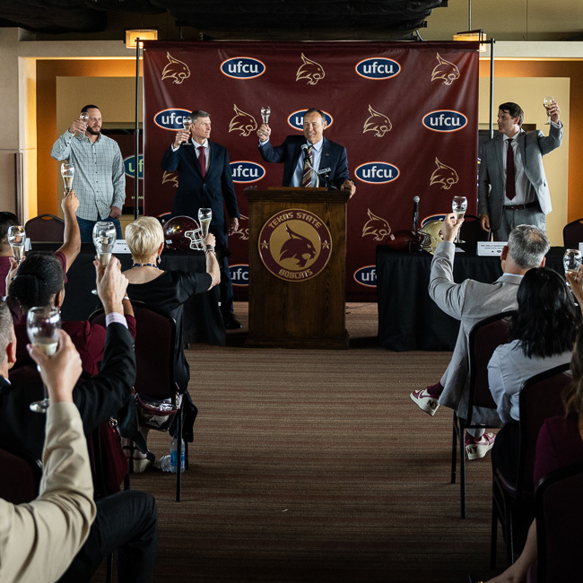 Press conference for the UFCU stadium with everyone holding glasses to make a toast